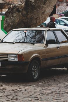 Retro car parked on cobbled city street, capturing urban nostalgia and vintage charm.