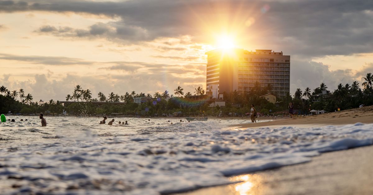 Warm sunset over a bustling beach and resort in Sri Lanka, capturing the golden hour glow.