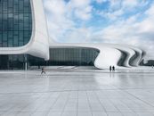 Woman in White Shirt and Black Pants Walking on White Concrete Floor