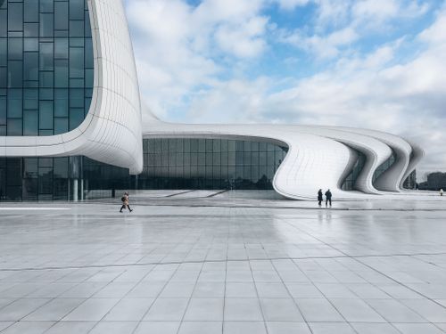 Free Explore the stunning modern design of the Heydar Aliyev Centre in Baku under a cloudy blue sky. Stock Photo