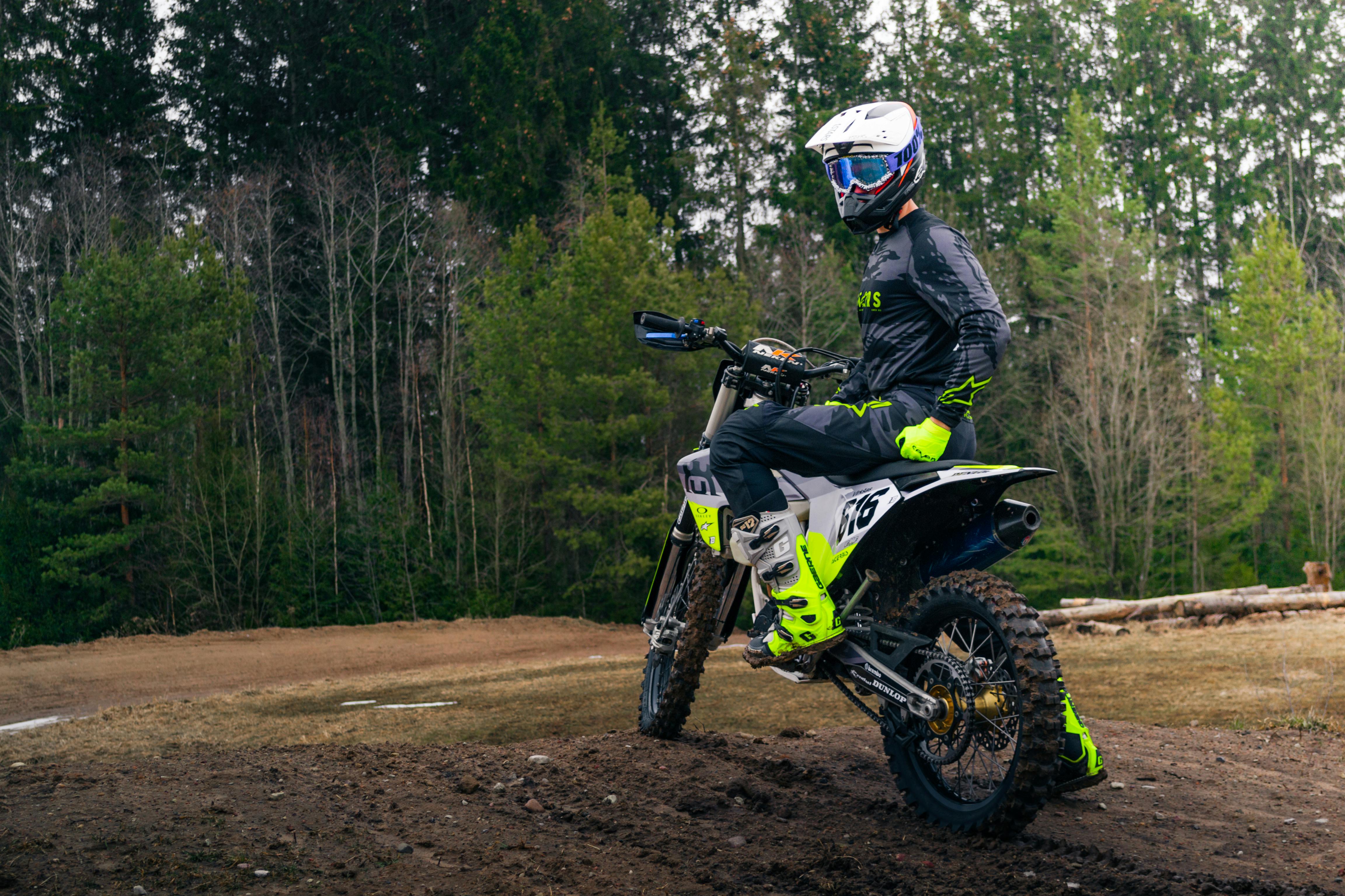 A dirt bike rider on a challenging off-road trail surrounded by nature.