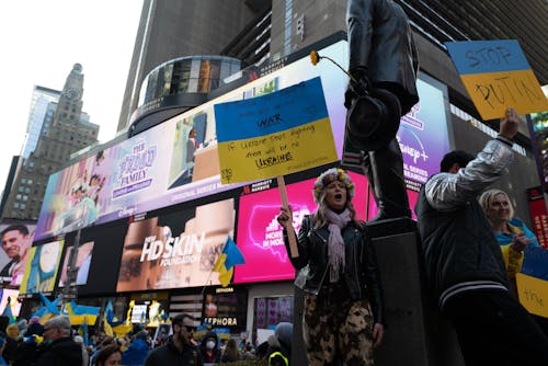 Woman in Black Jacket Holding Placard