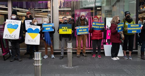Free Group of Protesters Wearing Face Mask while Holding Placards Outside the Commercial Establishment Stock Photo