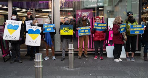 Group of Protesters Wearing Face Mask while Holding Placards Outside the Commercial Establishment