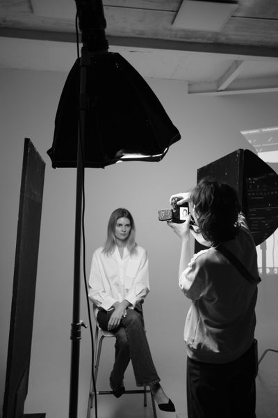 Photographer shooting a sitter in a daylight studio — photo by Diana Dunaeva on Pexels