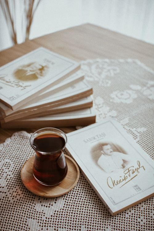 Free A cozy setup featuring Turkish tea and books on a lace-covered wooden table. Stock Photo