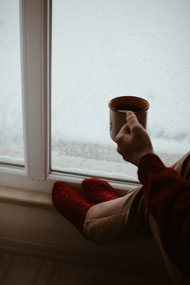 Drinking Coffee By The Window During Winter