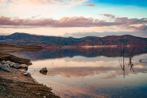 Free Serene mountain lake with reflected sky at sunset, offering a tranquil natural landscape. Stock Photo