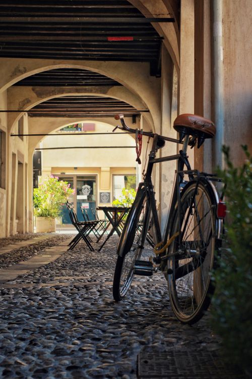 Free Vintage bicycle parked beneath charming archway in Treviso, Italy, showcasing classic European architecture. Stock Photo