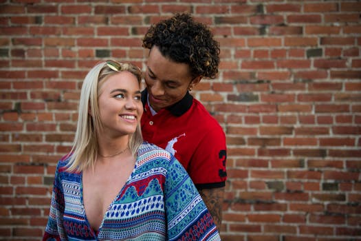 一对恩爱的夫妇靠着砖墙，在户外分享快乐的时刻