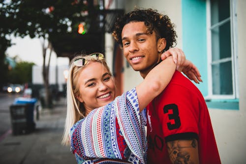 Close-Up Photo of Woman Hugging a Guy