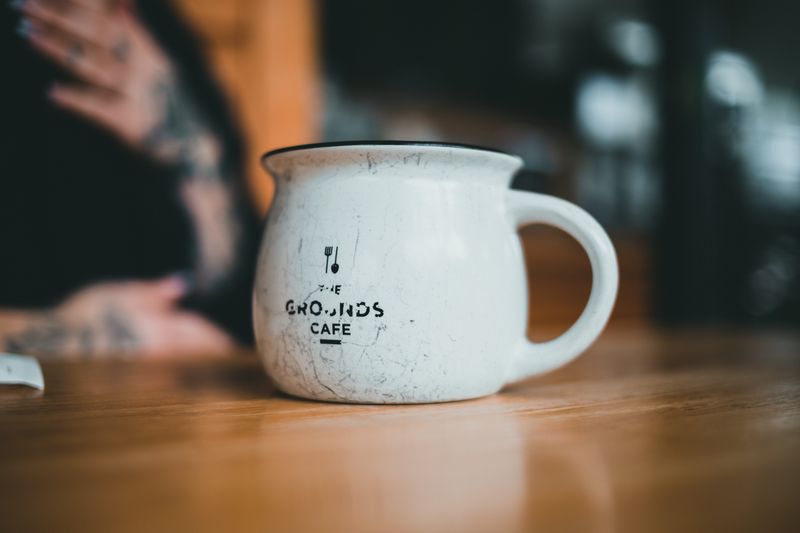 Branded ceramic mug with printed logo on a wooden table