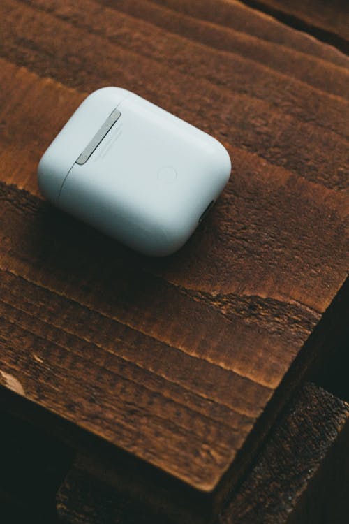 Close-Up Shot of Earbuds on a Wooden Table