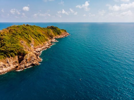 A stunning aerial shot of Thailand's lush coastline against a vibrant blue ocean.