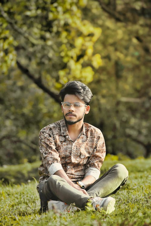 Man in Brown Shirt Sitting on Grass