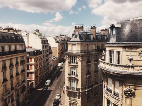 A captivating view of Parisian architecture and city streets under a bright, cloudy sky.