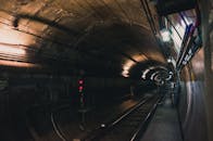 探索光线昏暗、阴森的地铁隧道，展现空荡荡的火车轨道和工业元素