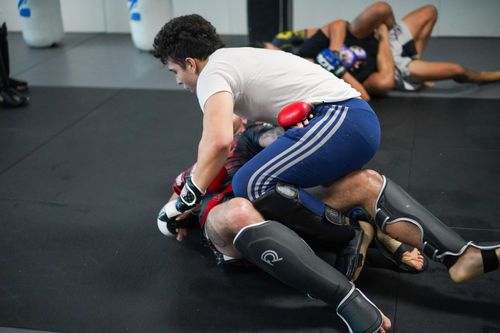 Free Two men engage in a martial arts sparring session on a gym mat, showcasing intense training. Stock Photo