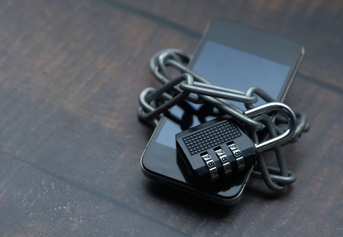 Padlock and chain over a device, representing access control