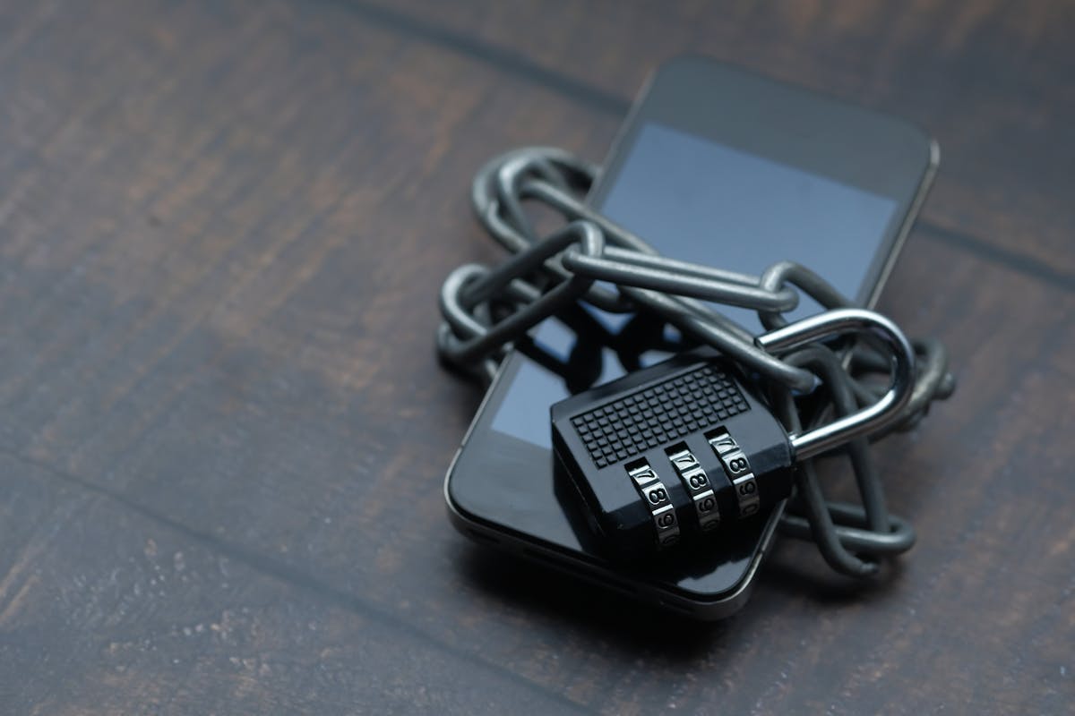 Smartphone avvolto da una catena con un lucchetto a simboleggiare sicurezza