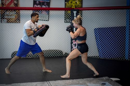 Free A man and woman engage in mixed martial arts training inside an indoor gym. Stock Photo
