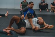 2 Men in Blue and Black Shirts and White Shorts Lying on Black Floor