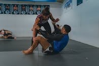 Two People Wrestling on a Gray Mat