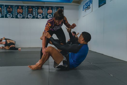 Two athletes engaged in grappling on a gym mat, showcasing strength and technique.