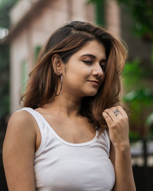 A Woman in White Tank Top with Her Eyes Closed