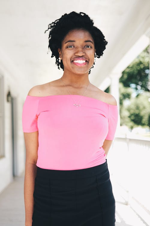 Smiling Woman Wearing Pink Off-shoulder Short-sleeved Blouse and Black Skirt Selective Focal Photo