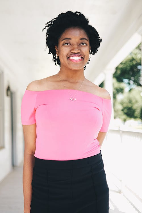 Mujer Sonriente Vistiendo Blusa De Manga Corta Con Hombros Descubiertos Rosa Y Falda Negra Foto Focal Selectiva