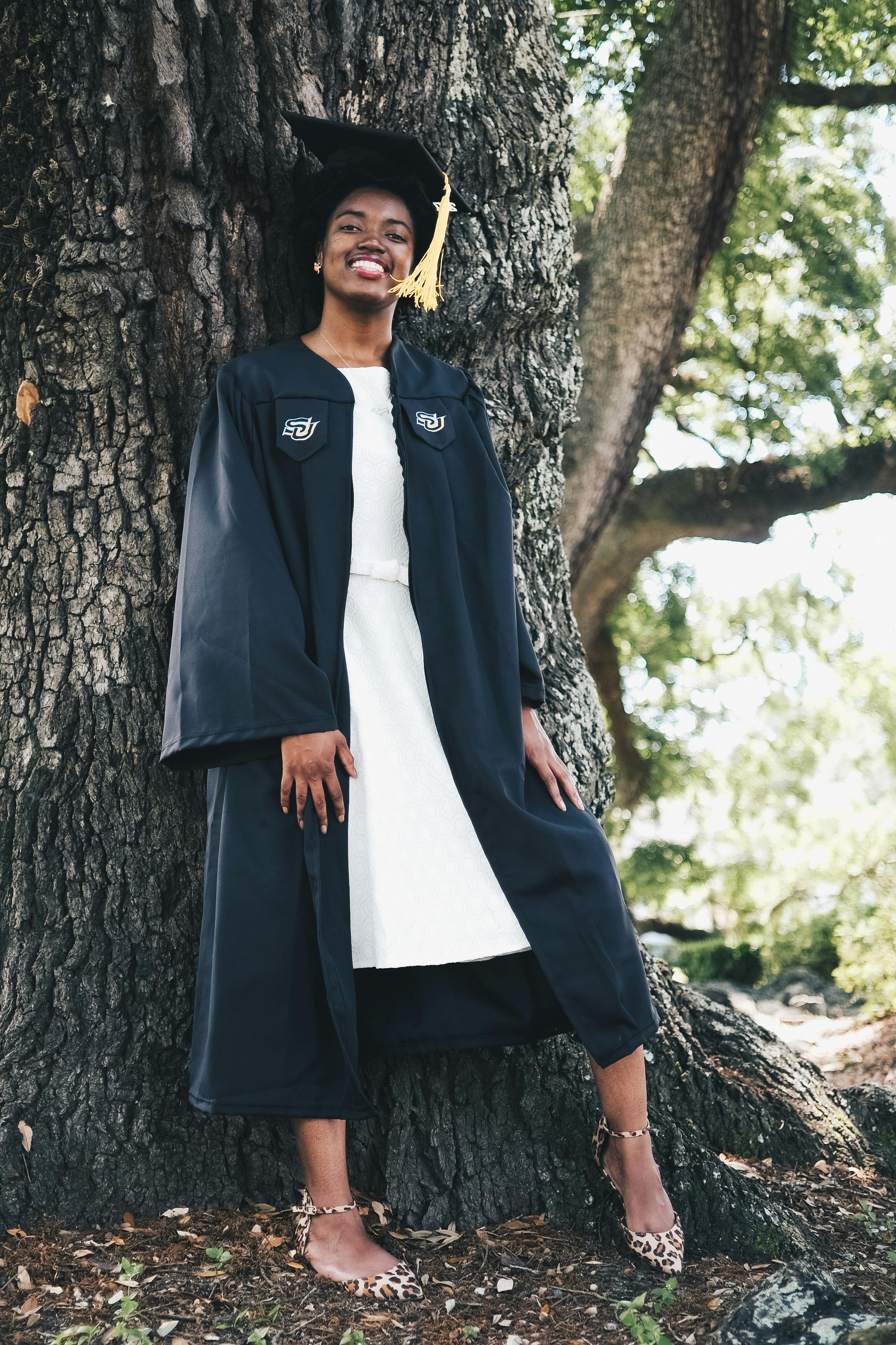 Happy African Student in Black Graduation Gown and Cap Raises Masters  Degree Diploma Above Head on White Background Stock Photo - Image of  academic, university: 273876560