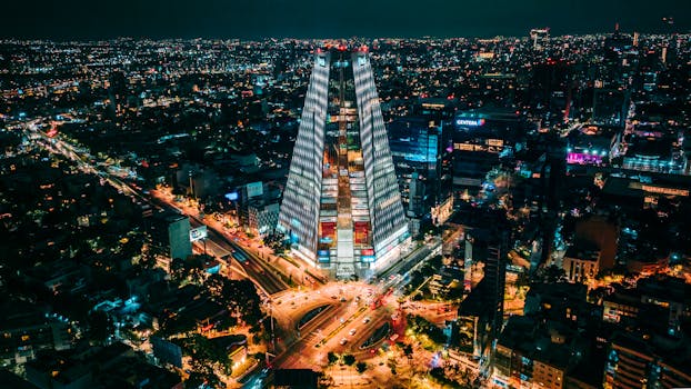 A captivating aerial night view of Mexico City with illuminated skyscrapers and bustling streets.