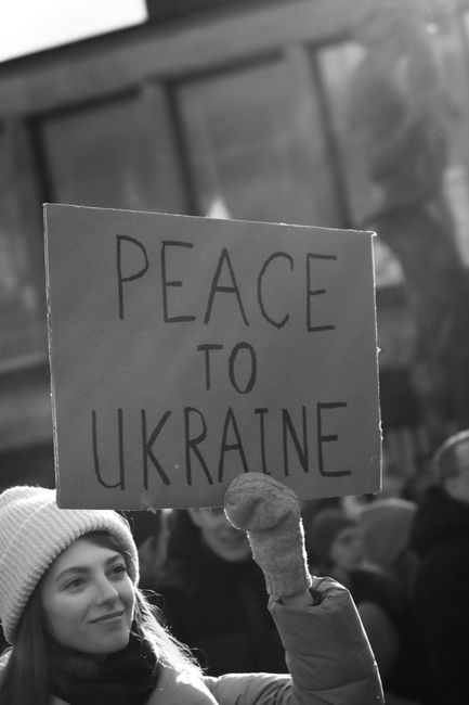 Black and white photo of a protester holding a peace sign for Ukraine in Gothenburg.