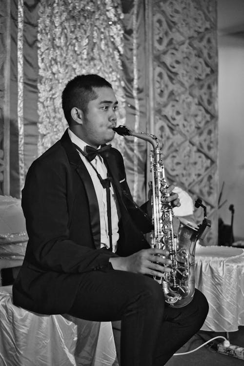 Grayscale Photo of a Man Playing Saxophone