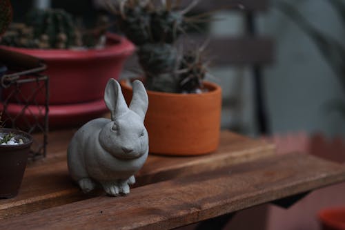 Gray Rabbit Figurine on Brown Wooden Table