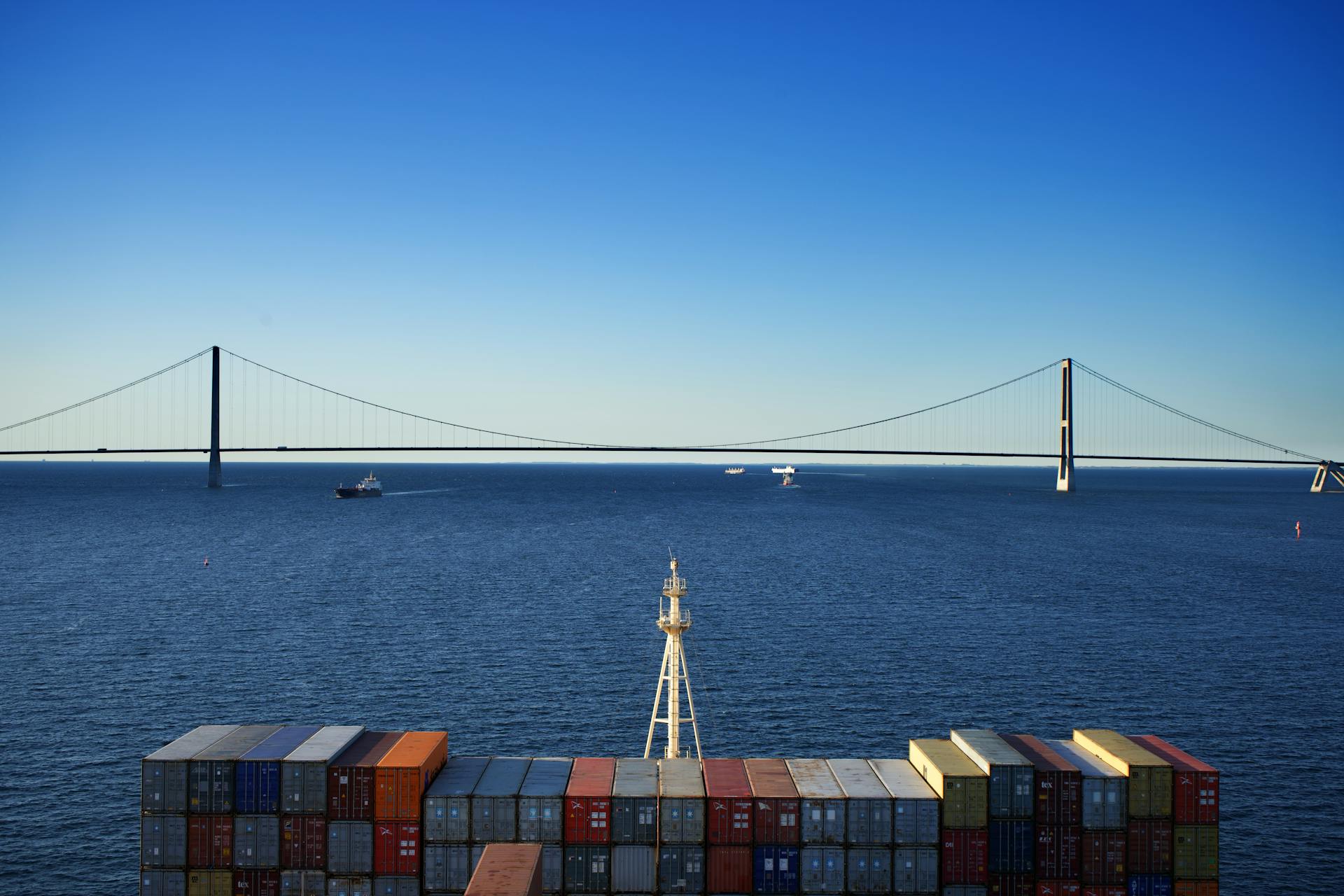 A scenic view of the Great Belt Bridge with shipping containers in Korsør, Denmark.