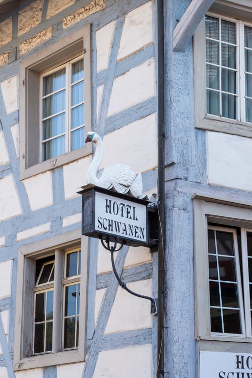 Free Elegant swan sign of Hotel Schwanen on a classic timber-framed building in Würzburg. Stock Photo