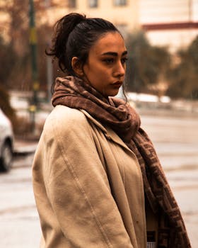 Moody portrait of a woman wearing a coat and scarf in rainy Tabriz, Iran.