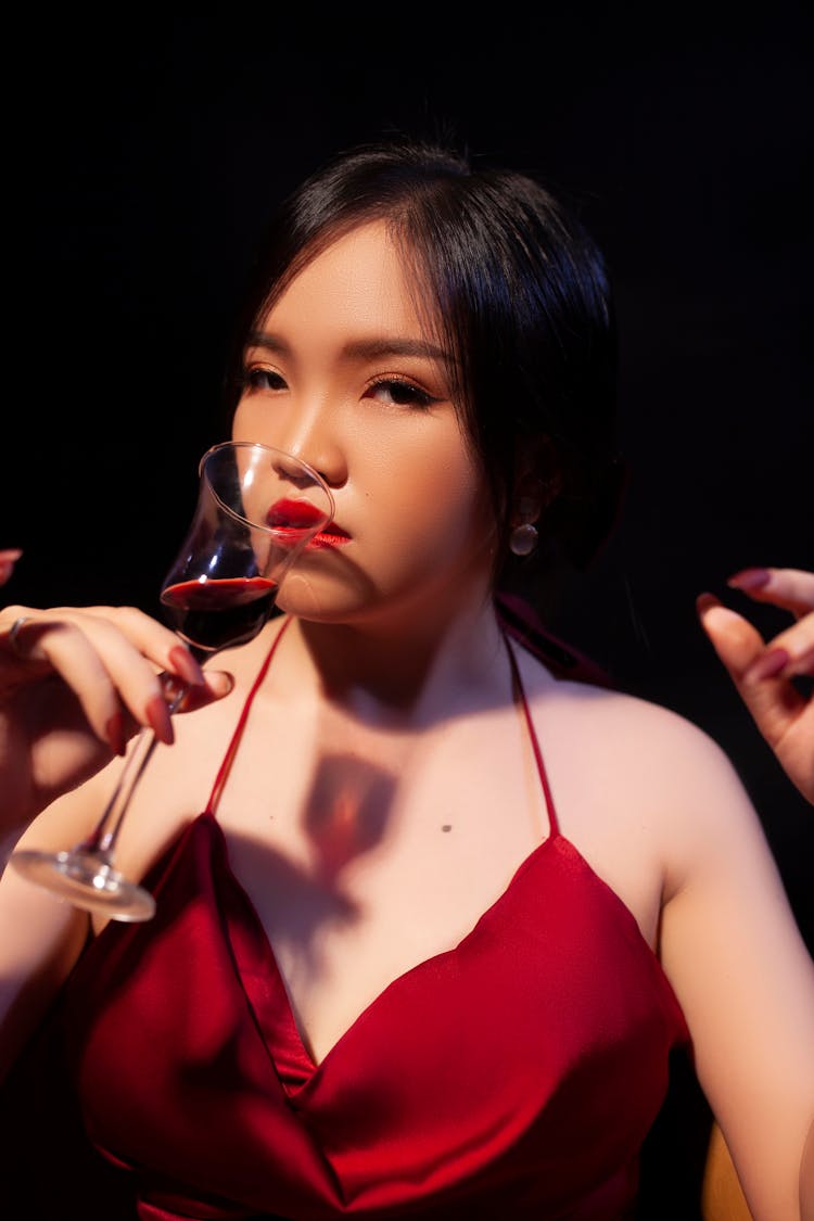 A Woman In Red Spaghetti Strap Top Drinking Wine