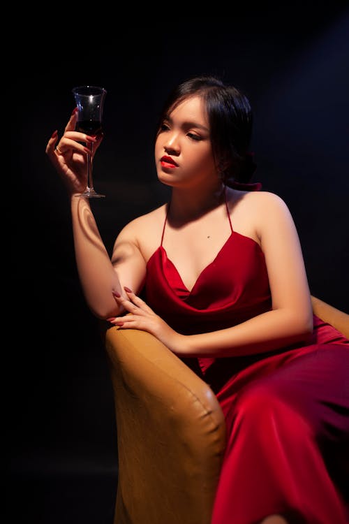Woman in Red Dress Holding a Wine Glass