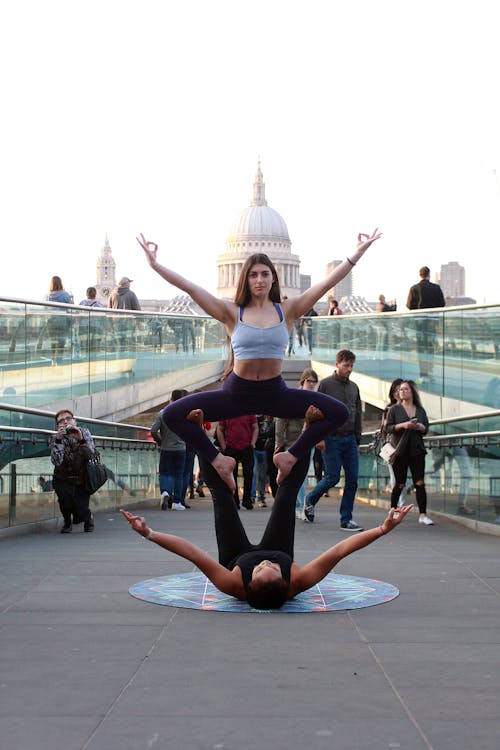 Two Women Performing Yoga on Street at Daytime