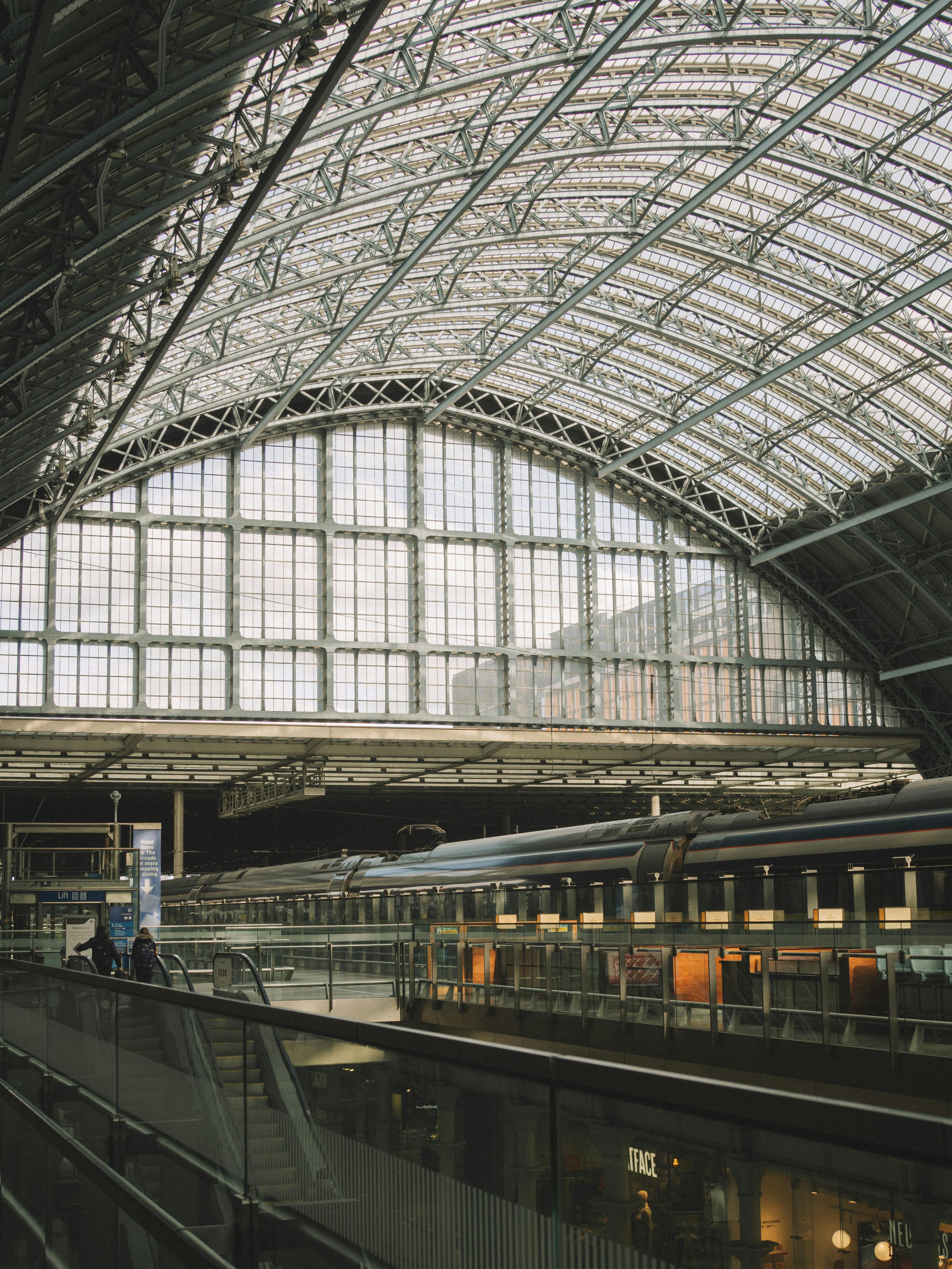 Spacious indoor view of a train station with glass panels and steel frame.