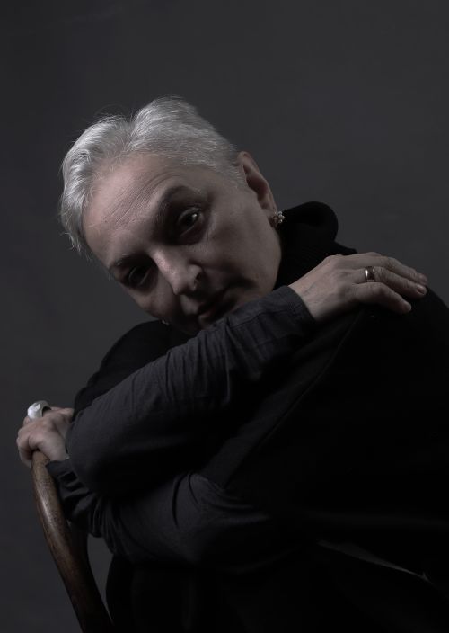 Free A dramatic portrait of a senior adult with short hair in black attire, conveying emotion. Stock Photo