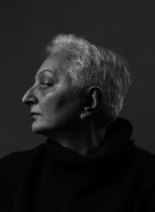 Free A striking black and white side profile portrait of a senior woman with short hair in a classic setting. Stock Photo