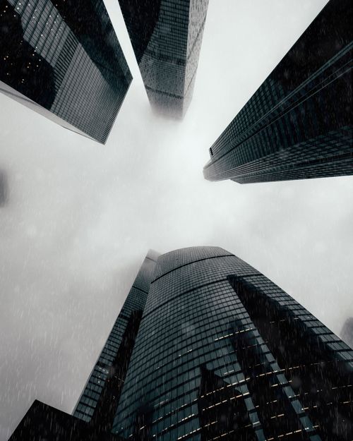 Free Dramatic upward view of Moscow's skyscrapers disappearing into the clouds on a rainy day, showcasing modern architecture. Stock Photo