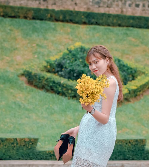 Free Woman Wearing White Lace Dress Holding Yellow Flower Bouquet Stock Photo