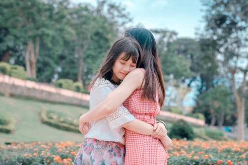 Candid Photography of Two Female Hugging