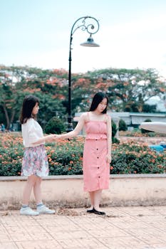 Two young women in summer dresses, enjoying a sunny day outdoors.