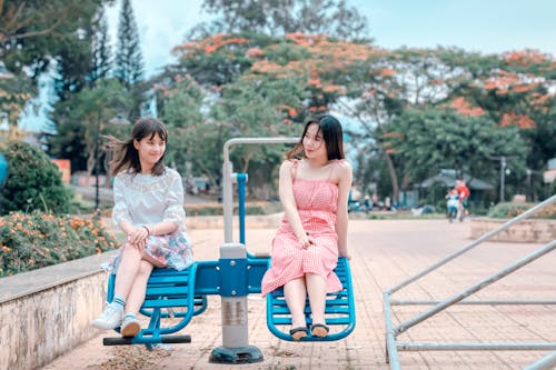 Two Women Sitting in Blue Park Ride